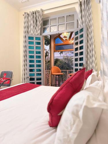 a bedroom with a white bed with red pillows at Angel paradise in Jaipur
