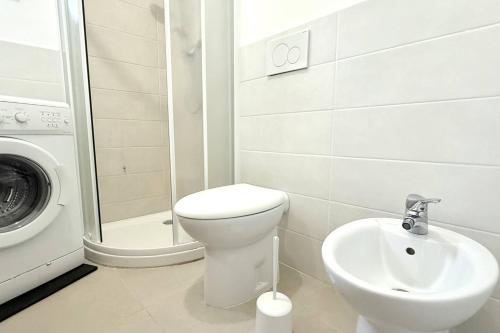 a bathroom with a toilet and a sink and a washing machine at Casa Vacanze Zefiro in Marzocca di Senigallia