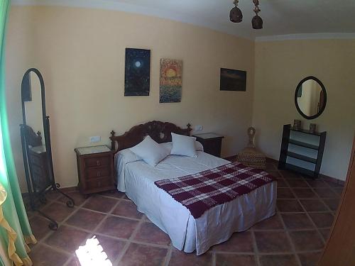 1 dormitorio con cama y espejo en Casa Rural Entreparques en El Bosque