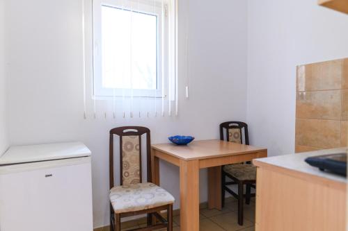a kitchen with a table and chairs and a window at Studio Merlin 2 in Soko Banja