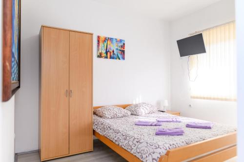 a bedroom with a bed and a wooden cabinet at Studio Merlin 2 in Soko Banja
