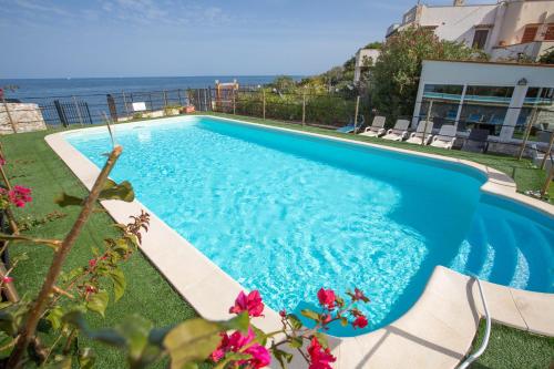 una piscina azul con vistas al océano en Villa Silvia by Ville in Palermo, en Casteldaccia