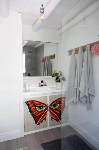 a bathroom with a sink with a butterfly painted on it at Riverfront Guesthouse ,Watermeadows farm in Sedgefield
