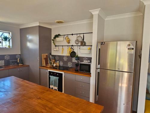 a kitchen with a stainless steel refrigerator and a table at House in Ellenbrook in The Vines