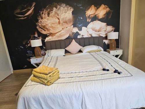 a bedroom with a large white bed with two lamps at House in Ellenbrook in The Vines
