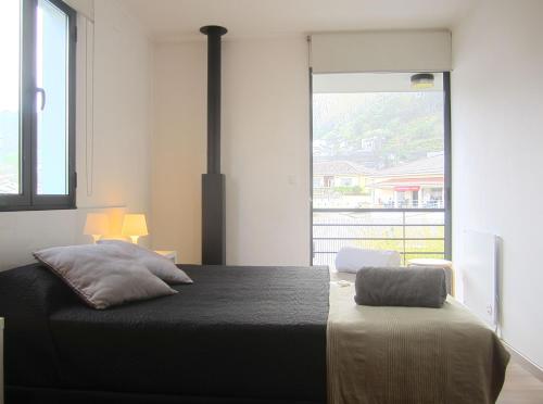 een slaapkamer met een bed en een groot raam bij Casa Das Furnas in Furnas