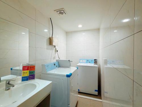 a bathroom with a sink and a washing machine at Wemeet Hotel in Pingtung City