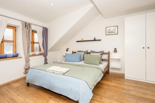 a bedroom with a bed with blue and green pillows at Penzion Quest in Loket