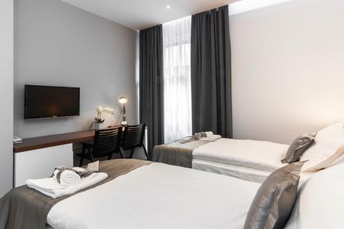 a hotel room with two beds and a television at Prima Luxury Rooms in Split