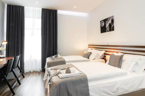 a hotel room with two beds and a table at Prima Luxury Rooms in Split