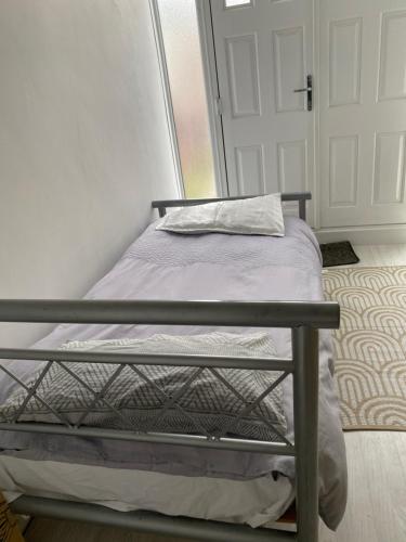a small bed in a room with a door at Varditchi in Redbridge