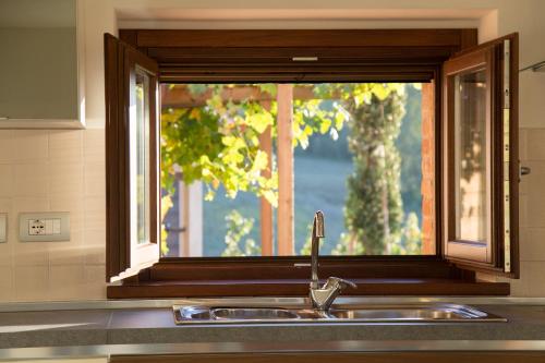 fregadero de cocina con ventana sobre una encimera de cocina en Country House Ca' Brunello, en Urbino