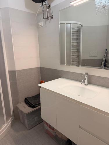 a bathroom with a sink and a mirror and a toilet at Torre 13F SeaView Studio in Lignano Sabbiadoro