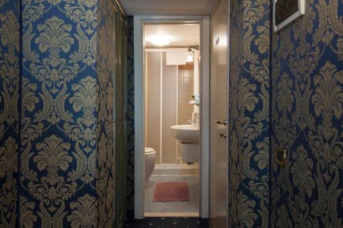 a bathroom with blue and gold wallpaper and a toilet at Ca' Della Loggia in Venice
