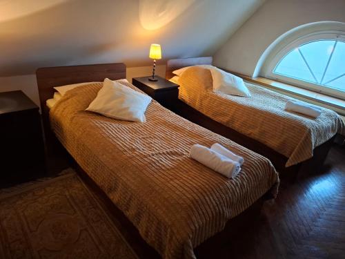 two twin beds in a room with a window at Dom Retro Pivnica in Jastrzębie Zdrój