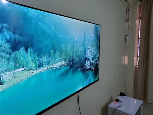 a large flat screen tv hanging on a wall at Nimmoh home in Rungiri