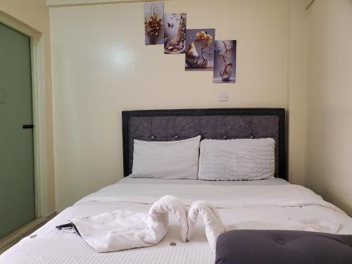 a bedroom with a bed with white towels on it at Nimmoh home in Rungiri