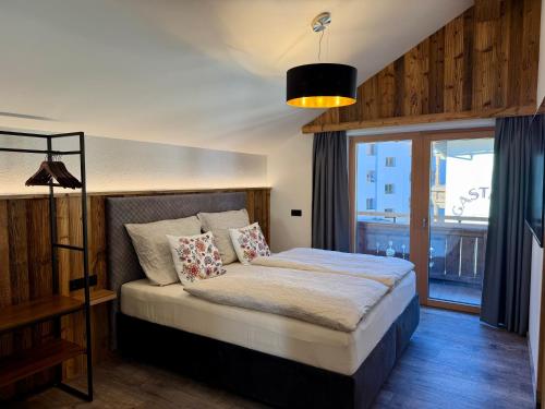 a bedroom with a bed and a large window at Das Lisal in Zell am Ziller