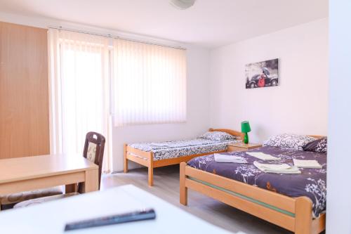 a bedroom with two beds and a desk and a table at Studio Merlin 4 in Soko Banja