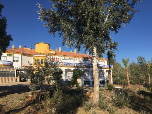 a house with a tree in front of it at Hotel Arco del Sol in Colmenar