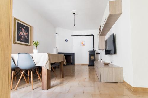 a living room with a table and a tv at Losa Rooms in Abbasanta