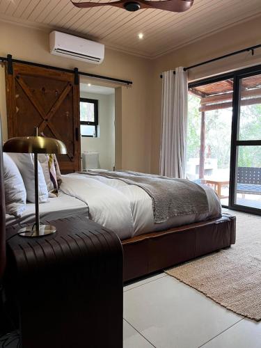 a bedroom with a large bed with a large wooden headboard at Rhula Villa - Stylish Private Safari Villa in Hoedspruit