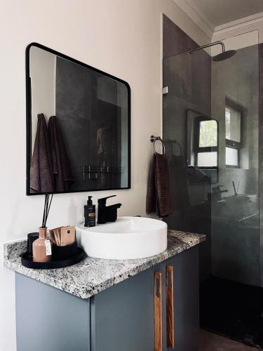 a bathroom with a white sink and a shower at Rhula Villa - Stylish Private Safari Villa in Hoedspruit