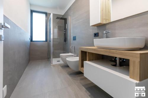 a bathroom with a white sink and a toilet at SYMPHONY HOUSE by Design Studio in Bellano