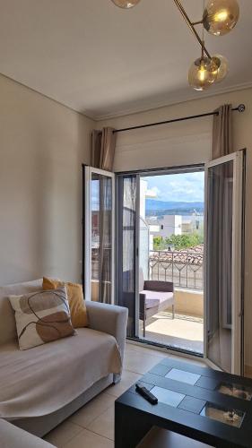 a living room with a couch and a view of a balcony at City Comfort Sparti in Sparta