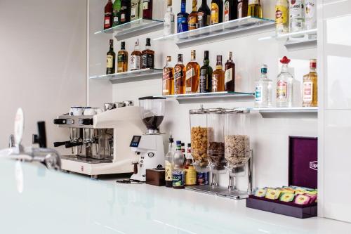 a kitchen counter with a mixer and bottles of alcohol at Hotel Oskar Business & Spa in Puławy