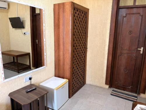 a bathroom with a sink and a mirror and a door at Karafuu Nyama Choma Lodge in Bwejuu