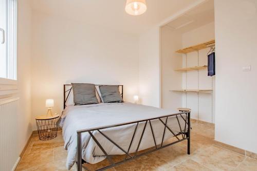 a bedroom with a bed in a white room at La Maison du Lac in Montceau-les-Mines