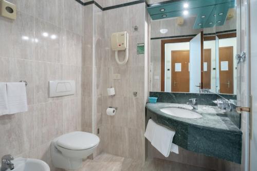 a bathroom with a sink and a toilet and a mirror at Alloggi Venca' in Chioggia