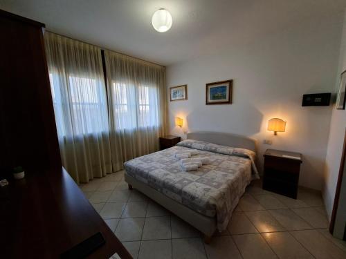 a bedroom with a bed and two tables and two lamps at Alloggi Venca' in Chioggia