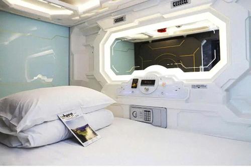 a room with a bed with a tv at Capsule Riverside in Ho Chi Minh City