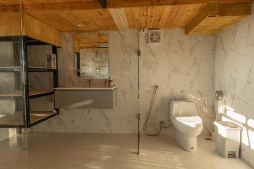 a bathroom with a toilet and a sink at Sunray Hill in Ranong