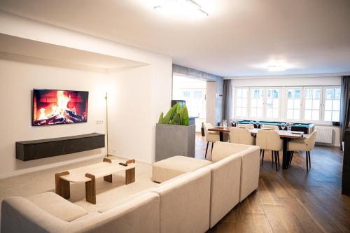 a living room with a couch and tables and a fireplace at Design Apartments Schloss Burg Solingen - BRIGHT Collection in Solingen