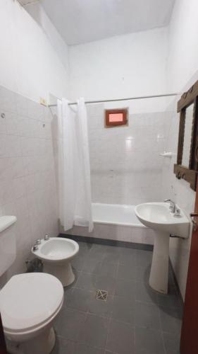 a bathroom with a toilet and a sink and a tub at Casa Alfonso 4 huéspedes y cochera gratis in Humahuaca