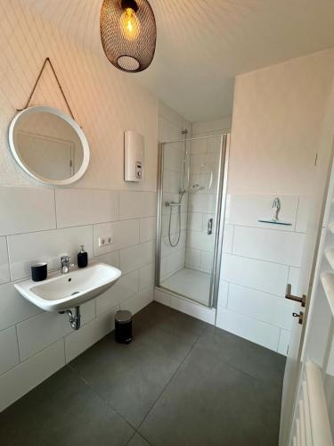 a white bathroom with a sink and a shower at Apartment im Grünen in Kroppach