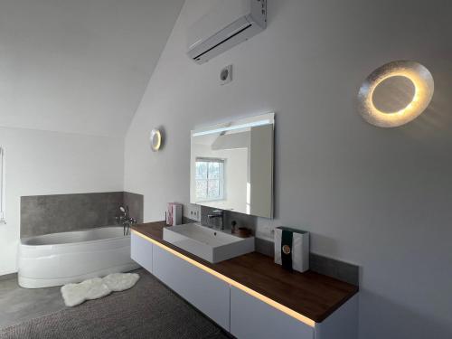 a bathroom with a sink and a tub and a mirror at Horse Lodge de Bélian in Hannut