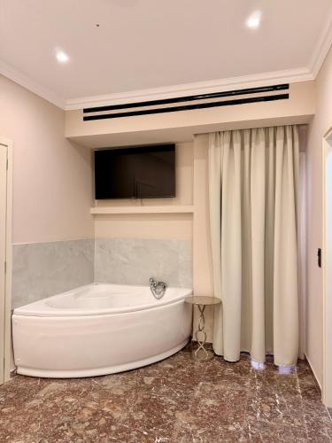 a white bath tub in a bathroom with a television at The Residence Myrina in Myrina