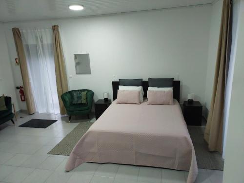 a bedroom with a large bed with pink pillows at Retiro das Camélias 3 in Lajes das Flores