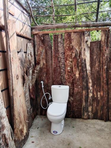 a bathroom with a toilet in a wooden wall at Mamba Yala in Tissamaharama