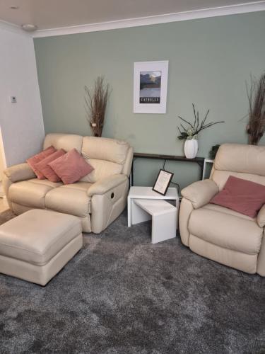 a living room with two couches and a couch at Plum Cottage in Keswick