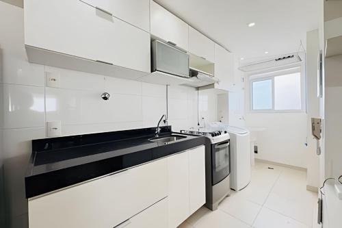 a white kitchen with a sink and a stove at Studio Mandarin + spectacular view + Umarizal in Belém