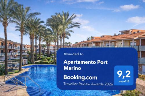a sign in front of a swimming pool with palm trees at Apartamento con piscina, terraza y parking gratis "Ideal familias" Cambrils in Cambrils