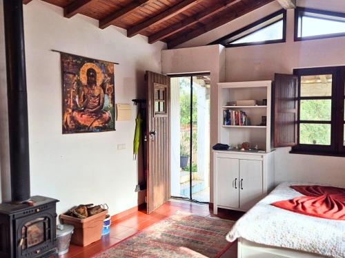 a bedroom with a bed and a stove in a room at Studio in peaceful village of São Martinho das Amoreiras in São Martinho das Amoreiras