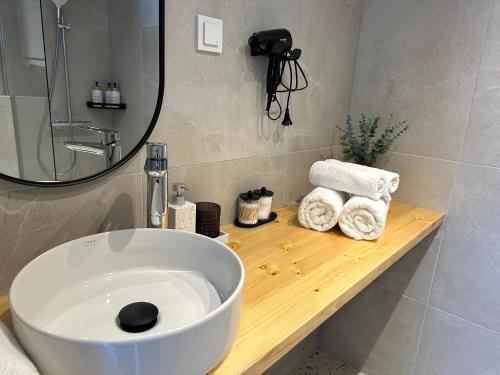 a bathroom with a sink and a mirror and towels at Greencabin - Cabin Escape in the Heart of Saaremaa in Pamma