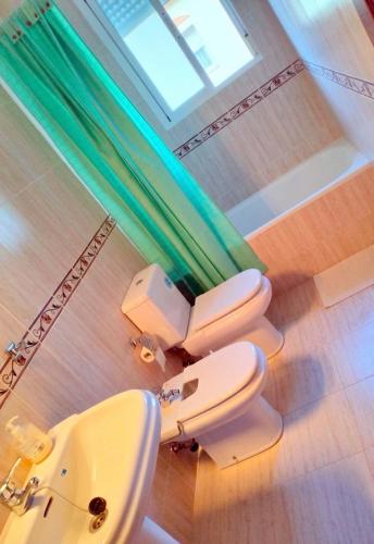 two toilets and a sink in a bathroom at Studio Nova in Priego de Córdoba