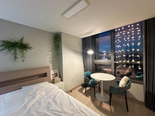 a bedroom with a bed and a table and chairs at Incheon Rest Stay in Taeam